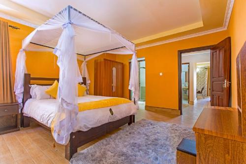 a bedroom with a bed with a canopy at Nokras Riverine Hotel & Spa in Sagana