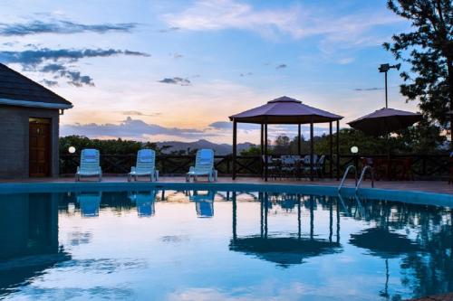 uma piscina com cadeiras e um gazebo em Nokras Riverine Hotel & Spa em Sagana