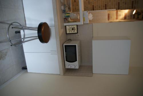 a small kitchen with a white refrigerator and a tv at Appartements Brussel in Brussels