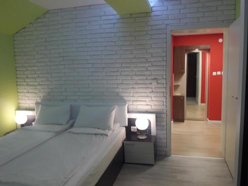 een slaapkamer met een bed en een bakstenen muur bij Shishkova 3 Apartment in Varna