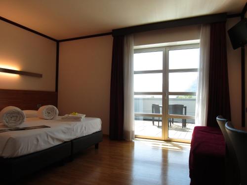 1 dormitorio con 1 cama y puerta corredera de cristal en Al Marinaio Hotel Garni, en Trento