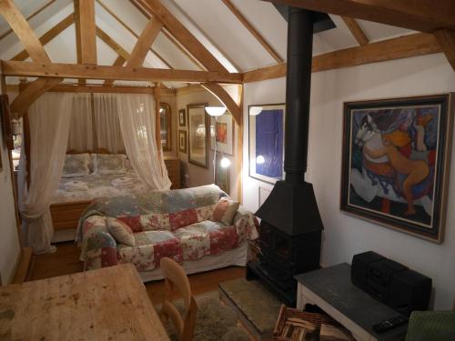 a living room with a fireplace with a couch and a stove at Wayside Cottage in Beaulieu