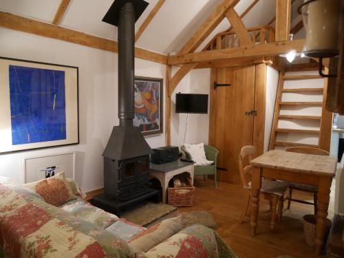 a living room with a stove and a couch at Wayside Cottage in Beaulieu