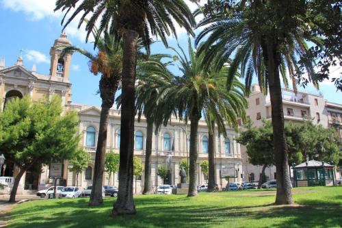 a group of palm trees in front of a building at Hotel Plaza in Taranto