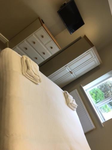 a bedroom with a bed and a television and a window at Llys y Dderwen - Oak Court in Aberystwyth