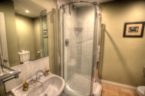 a bathroom with a shower and a sink at Dunster Castle Hotel in Dunster