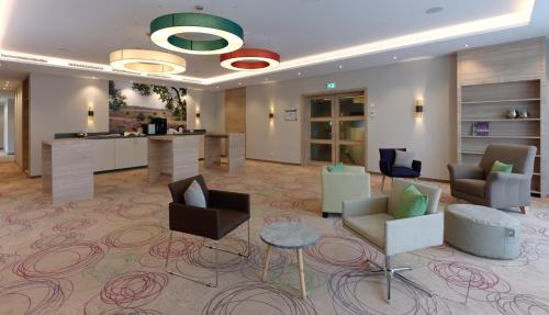 a lobby with couches and chairs and a bar at Hotel Sellhorn, Ringhotel Hanstedt in Hanstedt