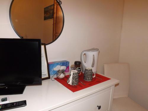 a desk with a computer monitor and a mirror on it at B&B CENTRAL TOMA 2 in Montecatini Terme