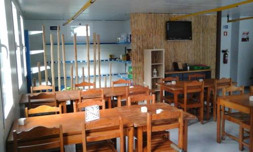 comedor con mesas y sillas de madera y TV en Parque de Campismo Orbitur Caminha, en Caminha