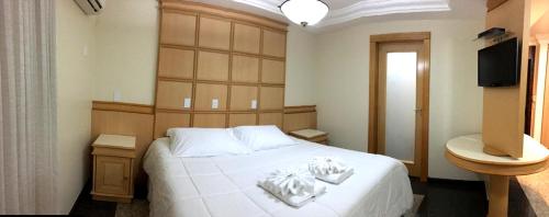 a bedroom with a white bed and a television at Ancelf Express in Palmas