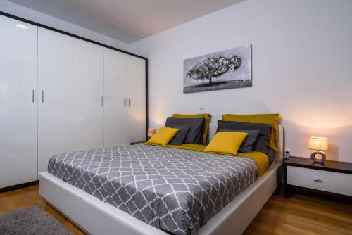 ein Schlafzimmer mit einem großen Bett mit gelben und blauen Kissen in der Unterkunft Apartments Gea in Trogir