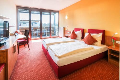 um quarto de hotel com uma cama e uma televisão em Hotel-von-Heyden em Tegernheim
