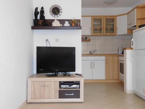 een keuken met een flatscreen-tv op een houten kast bij Apartment Vjera in Korčula