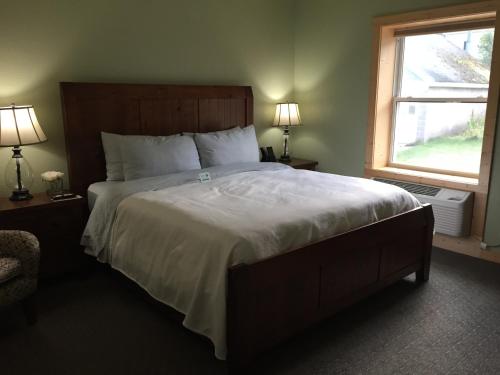 a bedroom with a large bed and a window at Roam Inn in Munising