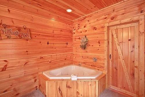 a bathroom with a tub in a wooden cabin at Mountain Seclusion in Sevierville