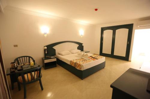 a bedroom with a bed and a table and a chair at Golden Beach 1 Ras Sedr in Ras Sedr