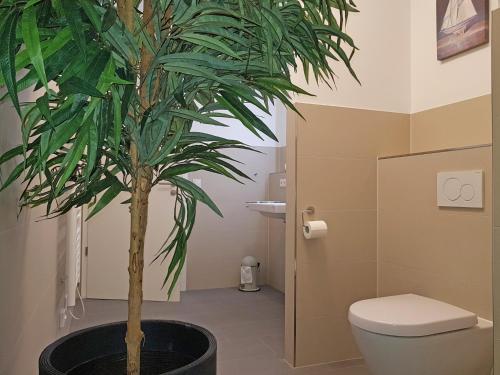 a bathroom with a toilet and a palm tree at Toms Kajute in Heiligenhafen