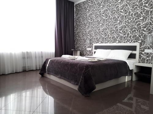 a bedroom with a bed with a patterned wall at IRIS apartments in Odesa