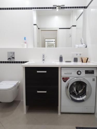 a bathroom with a washing machine and a sink at IRIS apartments in Odesa