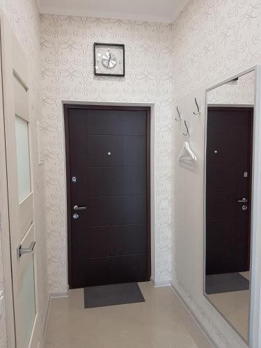 a hallway with a black door and a mirror at IRIS apartments in Odesa