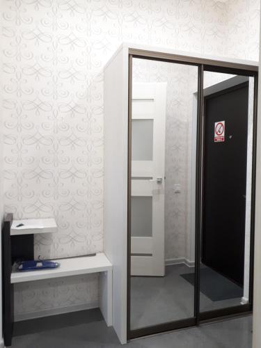 a bathroom with a mirror and a white wall at IRIS apartments in Odesa