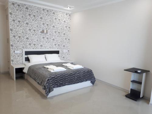 a bedroom with a bed and a wall at IRIS apartments in Odesa