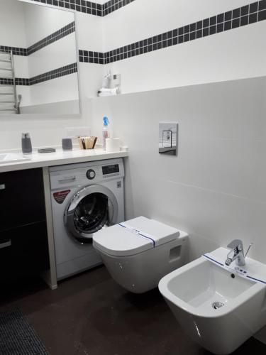 a bathroom with a washing machine and a sink at IRIS apartments in Odesa