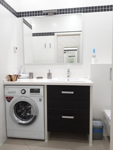 a bathroom with a washing machine and a sink at IRIS apartments in Odesa