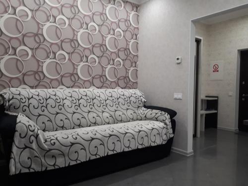 a couch in a room with a wall with plates at IRIS apartments in Odesa