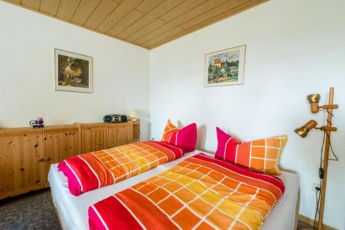 a bedroom with two beds with orange and orange sheets at Haus Fernblick in Bad Grund