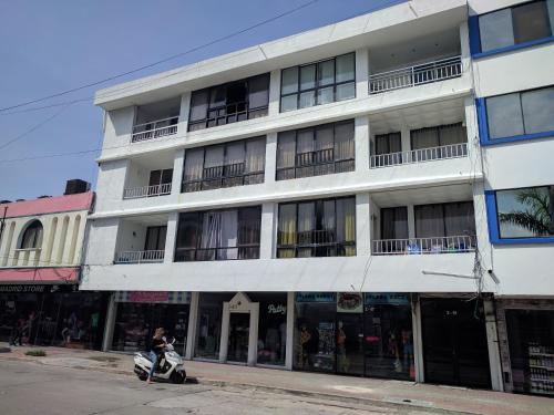 a person riding a scooter in front of a building at OUR Place 2 in San Andrés
