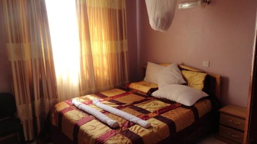 a bed with two pillows on it in a bedroom at Chester View Homestay in Syokimau