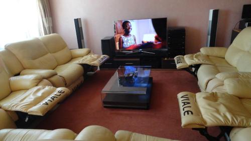 a living room with two couches and a tv at Chester View Homestay in Syokimau