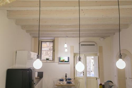 a kitchen with three lights hanging from the ceiling at Casa Graziosa in Siracusa