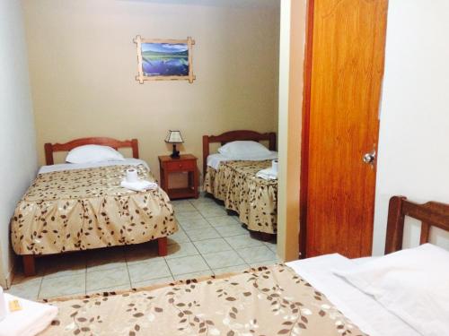 um quarto com duas camas e um quarto com duas camas em Hostal Oro Verde-Villa Rica em Villa Rica