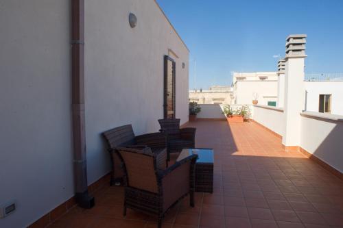 a balcony with chairs and a table on a building at B&B Suite Paciotti in Trani