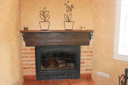 a fireplace with three plants on top of it at La Verdevilla in Anguix