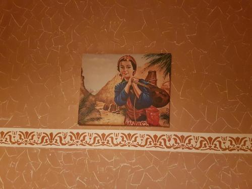 a picture of a man playing a violin on a wall at Résidence MARWA in Ouarzazate