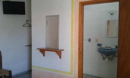 a bathroom with a sink and a mirror on a wall at Hotel Sarabi in Barra de Navidad