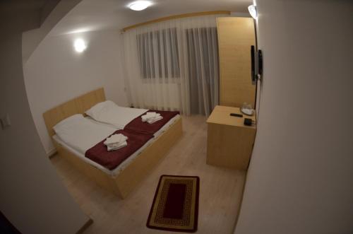 Habitación pequeña con cama y mesita de noche en Popas Azuga, en Azuga