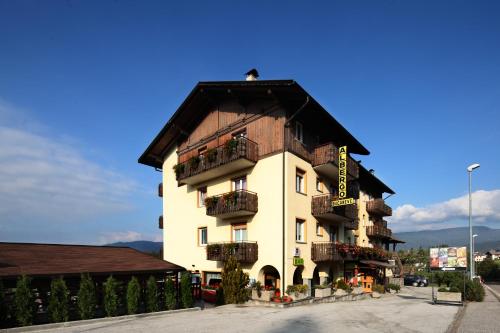 un grand bâtiment blanc avec un toit noir dans l'établissement Albergo Bucaneve, à Malosco