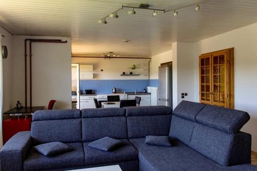 a living room with a couch and a kitchen at Apartment Bellevue in Blieskastel
