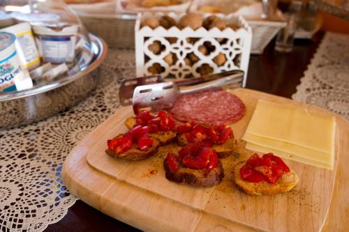 a cutting board with some food on a table at B&B Suite Paciotti in Trani
