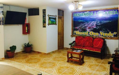 a living room with a red couch in a room at Hostal Oro Verde-Villa Rica in Villa Rica