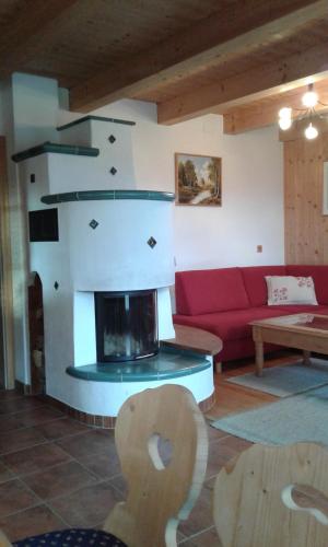 a living room with a fireplace and a red couch at Leitenschneider Hütte in Waggendorf