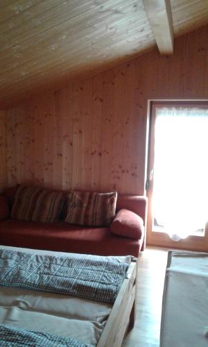 a living room with a couch and a window at Leitenschneider Hütte in Waggendorf