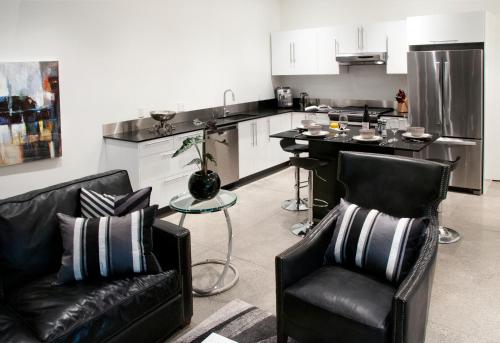 a living room with two chairs and a kitchen at The Cube in Cowichan Bay
