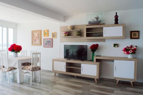 sala de estar con TV, mesa y sillas en Apartamento Ibañez, en Benidorm