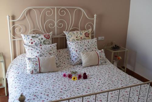 Un dormitorio con una cama con flores y muñecas. en Casa Rosario en Cartajima