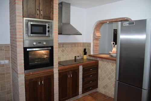 a kitchen with a refrigerator and a microwave at Casa Rosario in Cartajima
